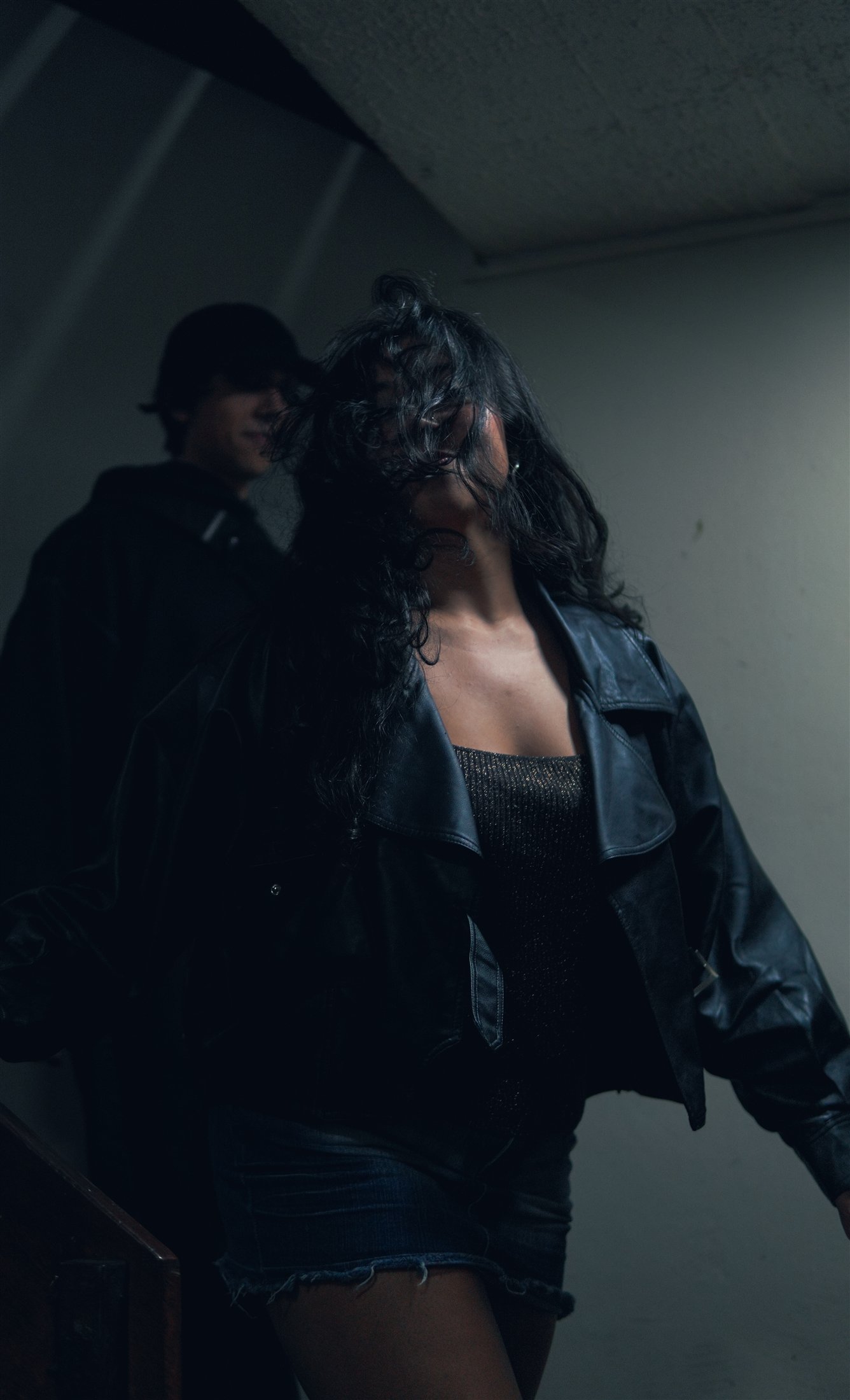 Retrato de una mujer con chaqueta oscura descendiendo por una escalera